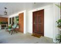 Cozy front porch with seating, brick siding, and a wooden front door at 17 Guerard Rd, Charleston, SC 29407