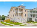 Charming two-story home with a double balcony, complemented by lush green grass and a manicured yard at 325 Blowing Fresh Dr, Charleston, SC 29492