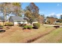 Well-maintained home featuring lush landscaping, mature trees, and a cozy, inviting front yard at 3360 Pinewood Dr, Ladson, SC 29456