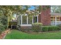 Side view of brick home with an enclosed sunroom area offering a view of the lush, green yard at 409 Dowling Ave, Walterboro, SC 29488