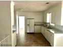 Well-lit kitchen features ample white cabinets, modern appliances, and durable flooring at 411 Maplewood Dr, Walterboro, SC 29488