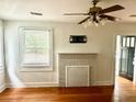 Bright living room with hardwood floors, a decorative fireplace, ceiling fan, and natural light at 411 Maplewood Dr, Walterboro, SC 29488