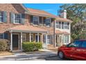 Charming brick townhouse with a covered porch and a red car in the driveway at 509 Reserve Way, Summerville, SC 29485