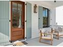 Inviting front porch with comfortable seating, wood door, and decorative shutters perfect for relaxation at 5742 Kiawah River Dr, Johns Island, SC 29455
