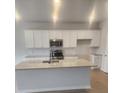 Modern kitchen with white cabinets, granite countertops, stainless steel appliances, and a center island at 598 Red Monarch Way, Moncks Corner, SC 29461