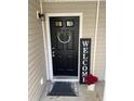 Welcoming front door with a wreath, 'WELCOME' sign, and decorative potted plants at 1320 Garland St, North Charleston, SC 29420