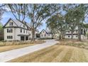 Beautiful home exterior with spacious lawn, mature trees, and long driveway at 215 Fell Pt, Daniel Island, SC 29492