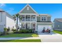 Charming two-story home with a welcoming porch, landscaped yard, and attached two-car garage with golf cart at 219 Seaworthy St, Summerville, SC 29486