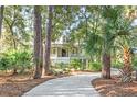 A quaint home with a tree-lined walkway leading to the front porch at 2824 Old Drake Dr, Seabrook Island, SC 29455