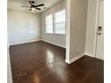 View of a living room with hardwood floors, neutral walls, and two windows for natural light at 3072 Adventure Way, Ladson, SC 29456