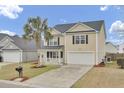 Charming two-story home featuring a palm tree, black shutters, a front porch, and a two-car garage at 315 Bradley Bend Dr, Moncks Corner, SC 29461