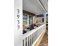 Inviting front porch with wicker chairs, white railing, and brick accents offer a cozy entrance to this lovely home at 3933 Bessemer Rd, Mount Pleasant, SC 29466