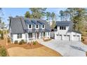 Two-story home featuring a three-car garage and large front yard, accented by the long concrete driveway at 3949 Bulow Landing Rd, Ravenel, SC 29470