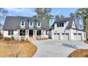 Striking two-story home with a three-car garage, enhanced by a manicured lawn and a concrete driveway at 3949 Bulow Landing Rd, Ravenel, SC 29470