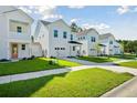 A row of pristine two-story homes each with a one-car garage and green lawn at 420 Queen View Ln, Charleston, SC 29414