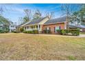 Ranch-style home boasts a charming porch, brick accents, and a neatly maintained lawn at 476 E Wimbledon Dr, Charleston, SC 29412