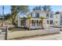 Beautiful home with a white picket fence, lush green lawn, mature trees, and a welcoming front porch at 519 Bank St, Mount Pleasant, SC 29464