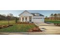 Inviting single-story home with a pristine lawn, covered porch, and a convenient two-car garage at 640 Cottage Landing Drive, Summerville, SC 29485