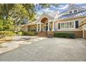Expansive front yard with a large driveway and lush landscaping surrounds this elegant home at 65 Surfsong Rd, Kiawah Island, SC 29455