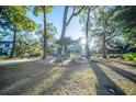 Beautiful home with mature trees creating shade and a well-manicured front yard at 676 Sterling Dr, Charleston, SC 29412