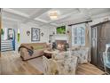 Cozy living room with a fireplace, wood floors, coffered ceilings, and two comfortable floral armchairs at 739 Shamrock Ln, Charleston, SC 29412