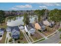 Picturesque neighborhood featuring a tranquil lake and well-maintained homes in a lush, wooded area at 8957 N Red Maple Cir, Summerville, SC 29485
