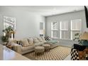 Bright living room with a large sectional couch, decorative rug, and abundant natural light from multiple windows at 109 Osprey Ridge Ln, Summerville, SC 29483