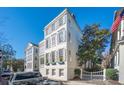 A charming white clapboard home with gray shutters sits beneath a clear blue sky at 11 Church St, Charleston, SC 29401