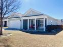 Inviting single-story home with a covered porch featuring red rocking chairs, complemented by a well-maintained lawn at 113 Mayfield Dr, Goose Creek, SC 29445