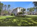 Expansive backyard featuring lush green grass and mature palm trees, ideal for outdoor activities at 144 Clark Ln, Summerville, SC 29483