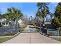 Gated driveway entrance surrounded by palm trees, ensuring privacy and leading to a beautiful property at 144 Clark Ln, Summerville, SC 29483