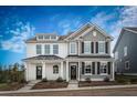 Inviting two-story home with white and gray siding, complemented by black shutters and a stylish covered entrance at 231 Abercom Place Dr, Moncks Corner, SC 29461