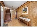 Inviting foyer with wood-paneled walls, hardwood floors, and decor on a console table at 29 Nassau St, Charleston, SC 29403