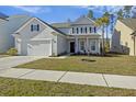 Charming two-story home features manicured lawn, attached garage, and inviting front porch at 310 Silent Bluff Dr, Summerville, SC 29486