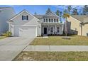 Charming two-story home features manicured lawn, attached garage, and inviting front porch at 310 Silent Bluff Dr, Summerville, SC 29486
