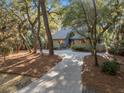 Landscaped single-Gathering home featuring a private driveway surrounded by mature trees at 385 Green Winged Teal Rd, Kiawah Island, SC 29455