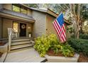 Welcoming front porch with rocking chair, American flag, and vibrant landscaping at 385 Green Winged Teal Rd, Kiawah Island, SC 29455