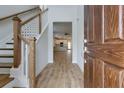 Inviting entryway with hardwood floors, wooden stairs, and a view into the open-concept kitchen at 418 Grove End Rd, Moncks Corner, SC 29461