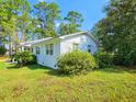 Charming home featuring a metal roof, landscaped yard, and lush greenery at 422 Academy Rd, Walterboro, SC 29488
