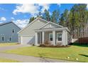 Attractive home with a lush green lawn, attached garage, and inviting covered entry at 4316 Cotton Flat Rd, Summerville, SC 29485