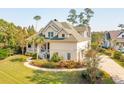 Two-story traditional home with lush green lawn, inviting front porch, and circular driveway at 4343 Ten Shillings Way, Ravenel, SC 29470