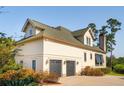 View of rear of house highlighting a two car garage and green shingled roof at 4343 Ten Shillings Way, Ravenel, SC 29470