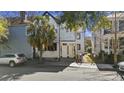 Charming two-story home with a fresh, light-blue facade, complemented by a mature palm tree and well-maintained front yard at 45 Bogard St, Charleston, SC 29403