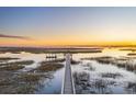 Sunset view of a wooden boardwalk across marshland to an observation deck at 4877 Sound View Dr, Mount Pleasant, SC 29466