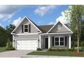 Cozy one-story home featuring gray siding, a front-entry garage, and charming curb appeal at 512 Eagleview Dr, Moncks Corner, SC 29461
