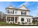Beautiful two-story home boasts white siding, black shutters, and a classic design at 709 Alma Square Dr, Moncks Corner, SC 29461