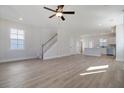Spacious living room with hardwood floors, staircase, and a view into the kitchen at 722 Rumbling Leaf Ln, Summerville, SC 29486
