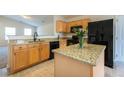 Updated kitchen with granite countertops, island, black appliances, and tile flooring at 7919 New Ryder Rd, North Charleston, SC 29406