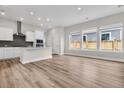 Spacious living area with wood-look floors, white kitchen, and natural light at 810 Gentle Breeze Dr, Summerville, SC 29486
