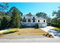 Inviting two-story home boasts a manicured lawn, charming stairway, and convenient two-car garage at 886 White Point Blvd, Charleston, SC 29412